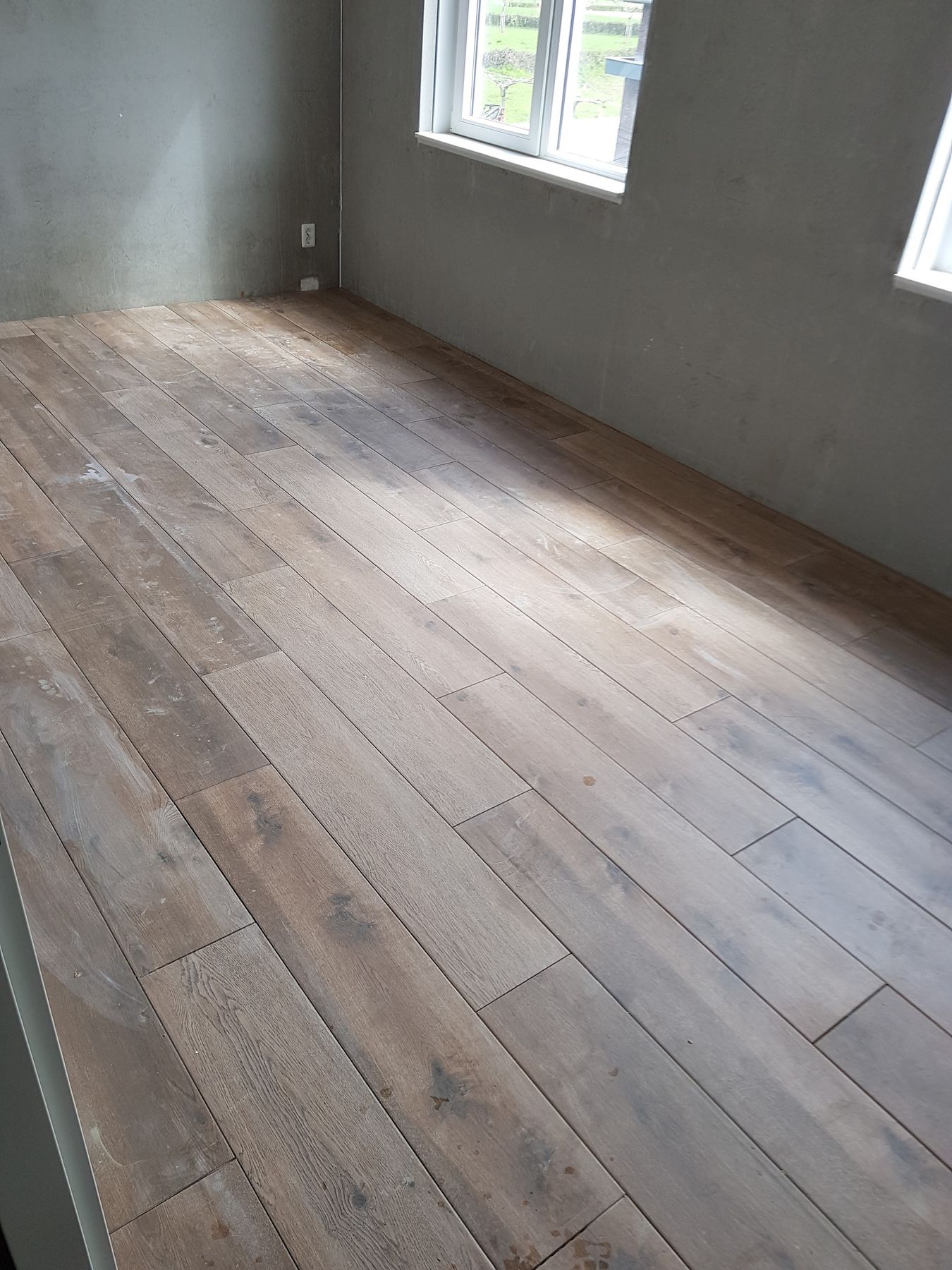 Kamer met een grote houtlook tegelvloer in lange planken gelegd